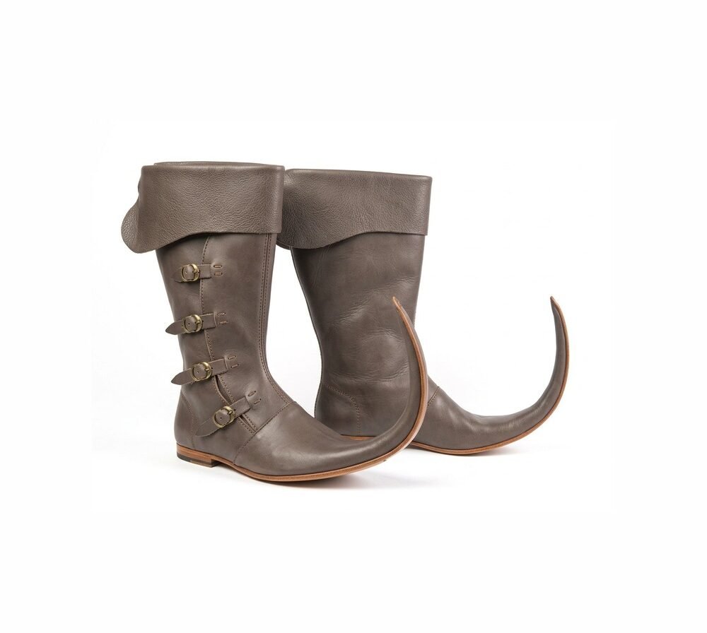 Pair of grey-brown medieval Schnabelstiefel with fold-over cuff, four brass buckles and long curved pointed toes on white background