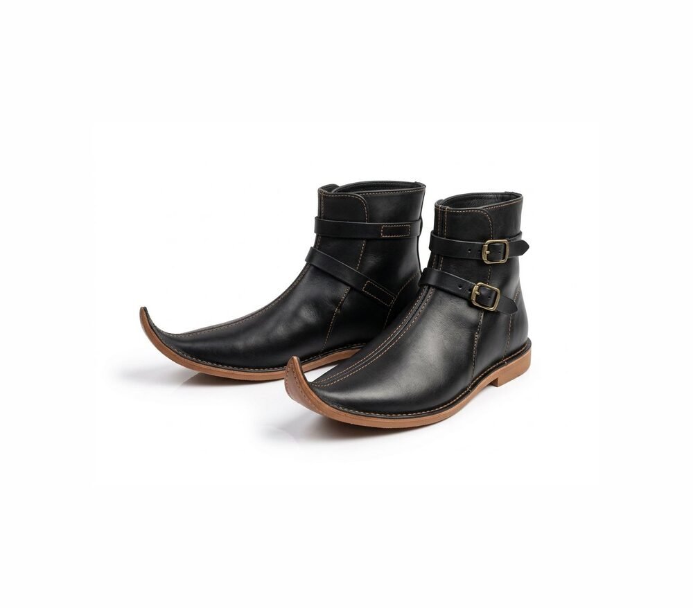 Pair of black medieval pointed boots with two brass buckle straps on white background